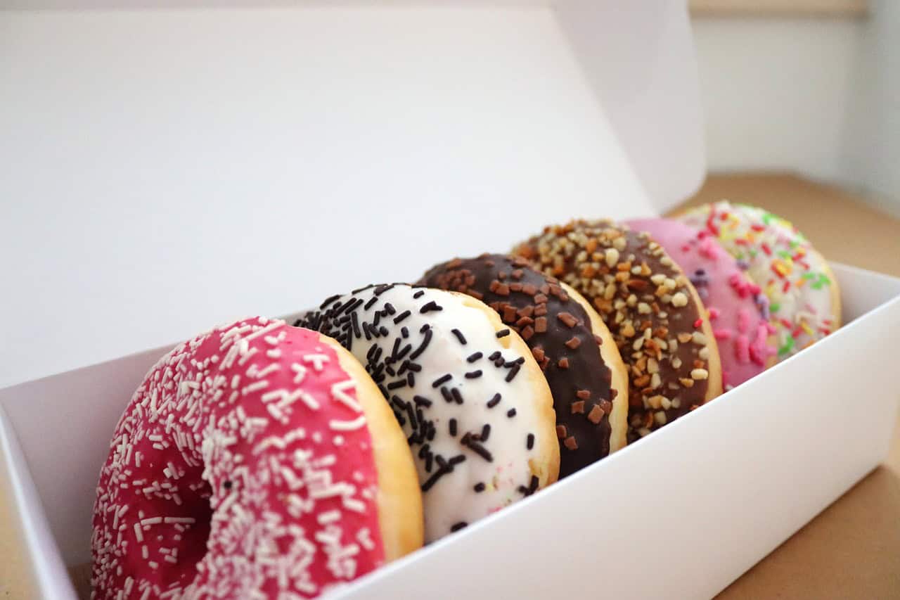 iced ring doughnuts in a white box